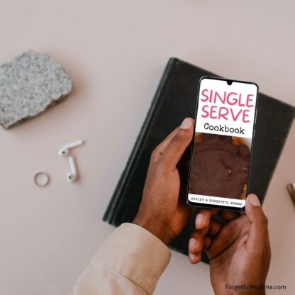 Hands holding a phone with the Single serve cookbook open on it